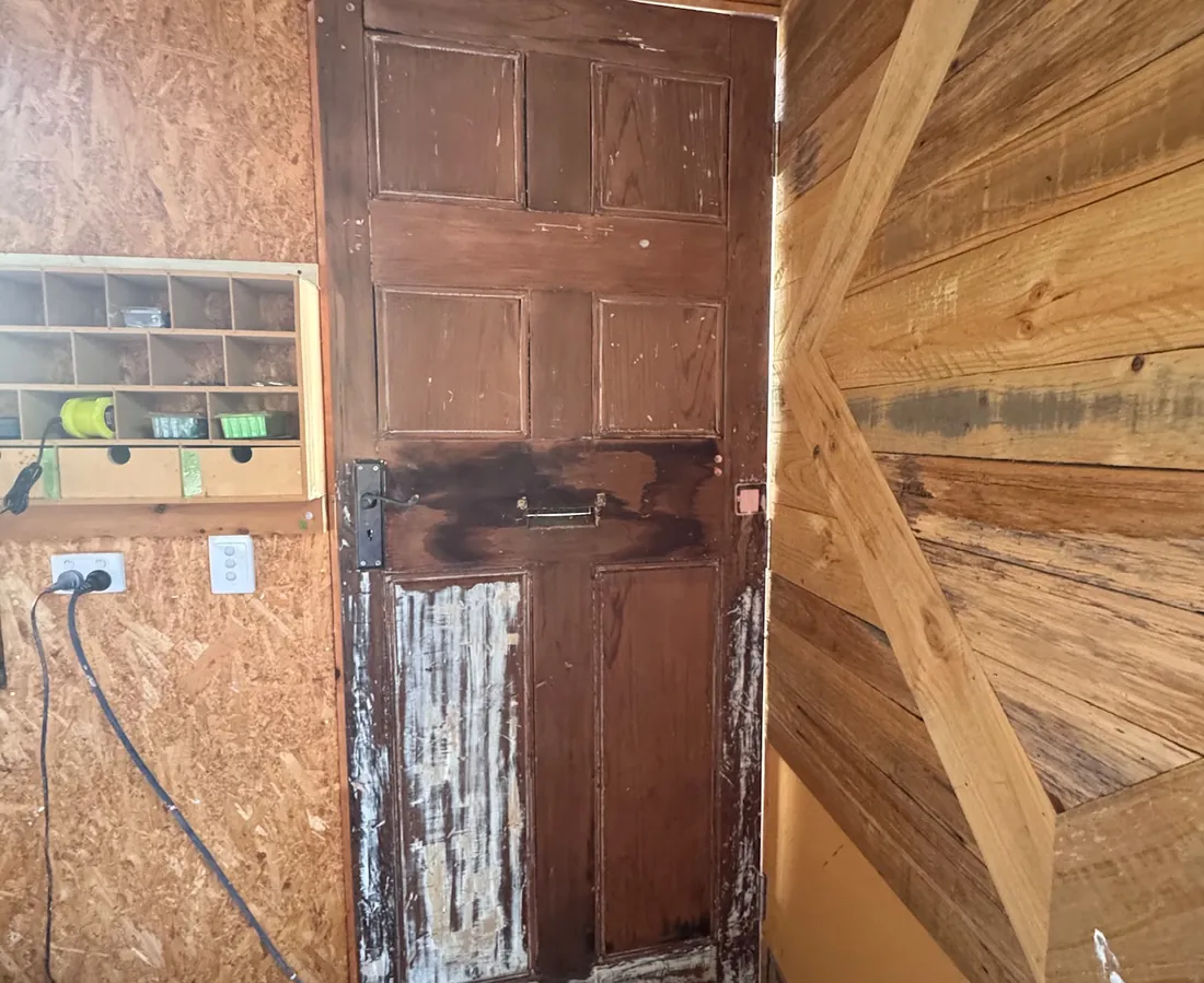 Timber front door with heavily worn, flaking original paint