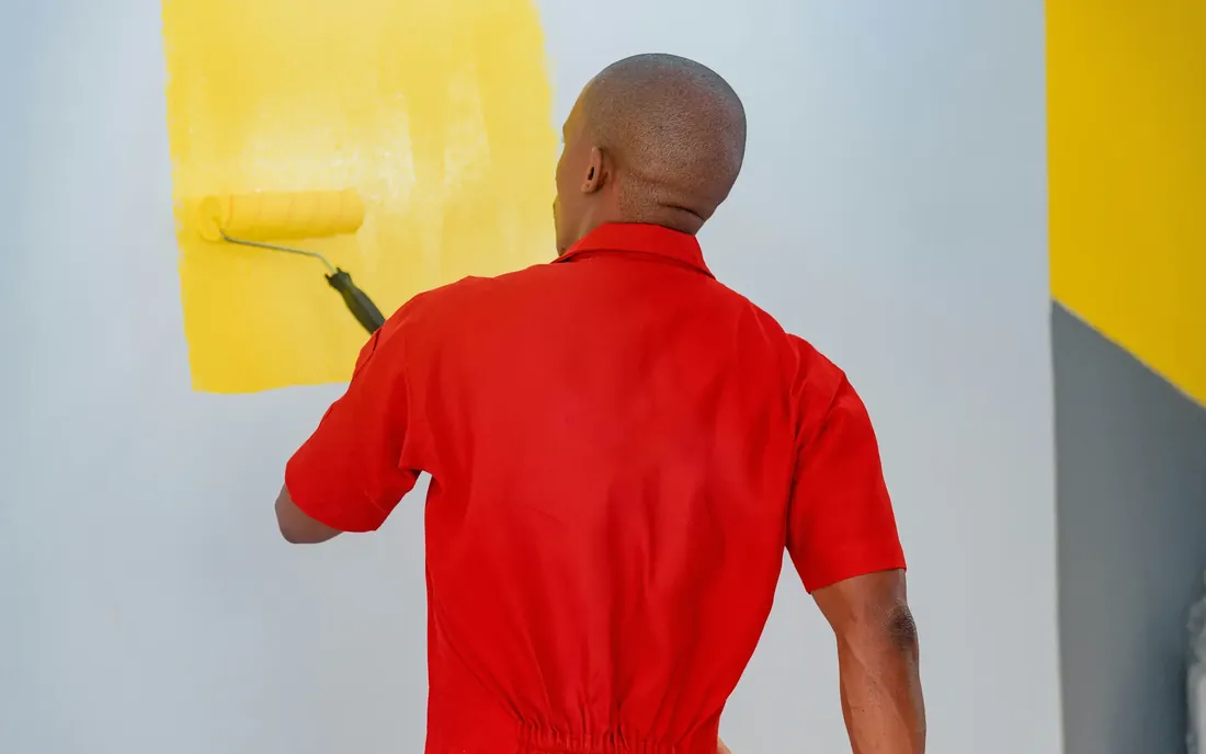 Painter rolling a fresh coat of paint onto a feature wall