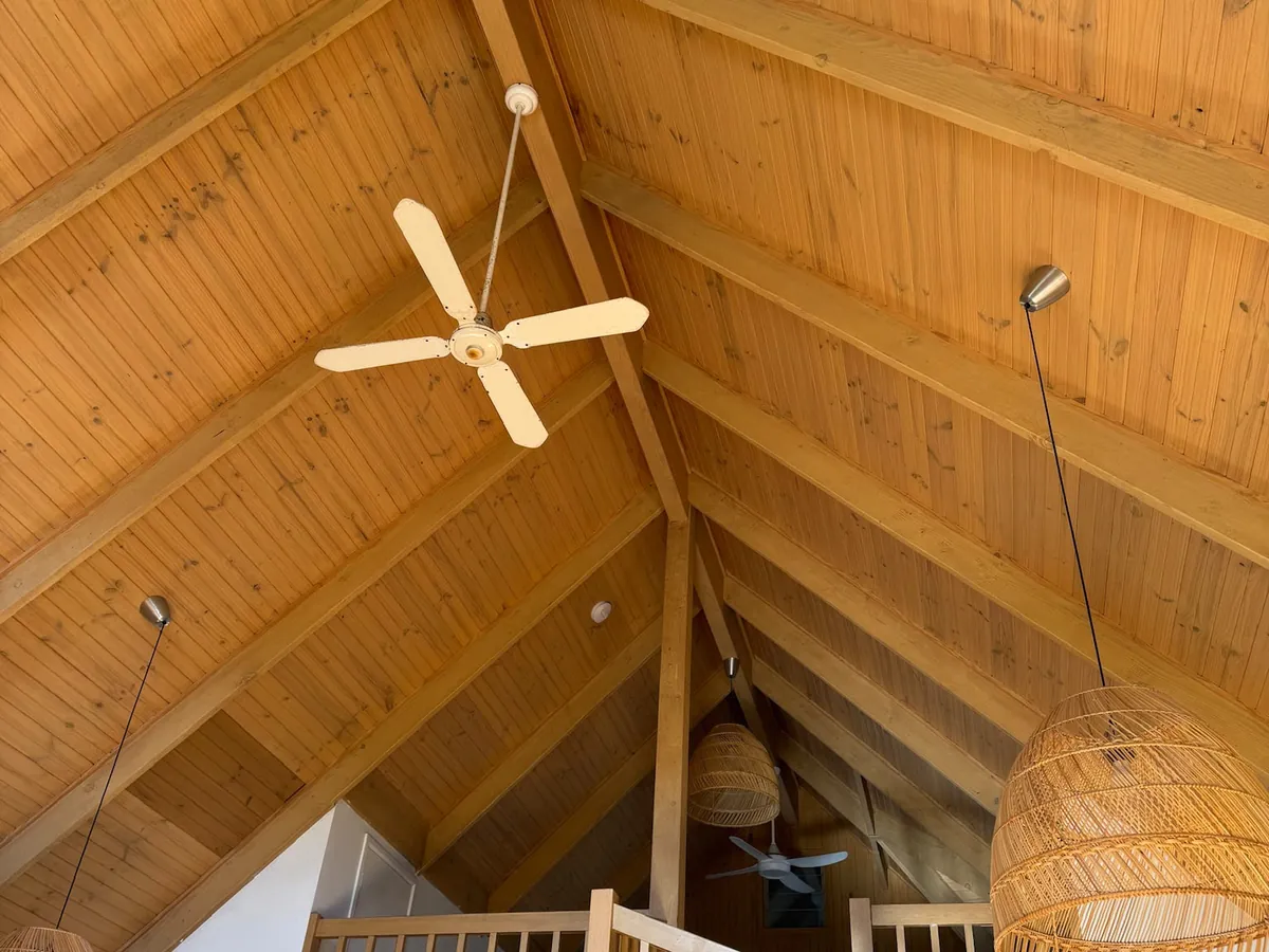 Vaulted timber-lined ceiling with exposed rafters and pendant lighting