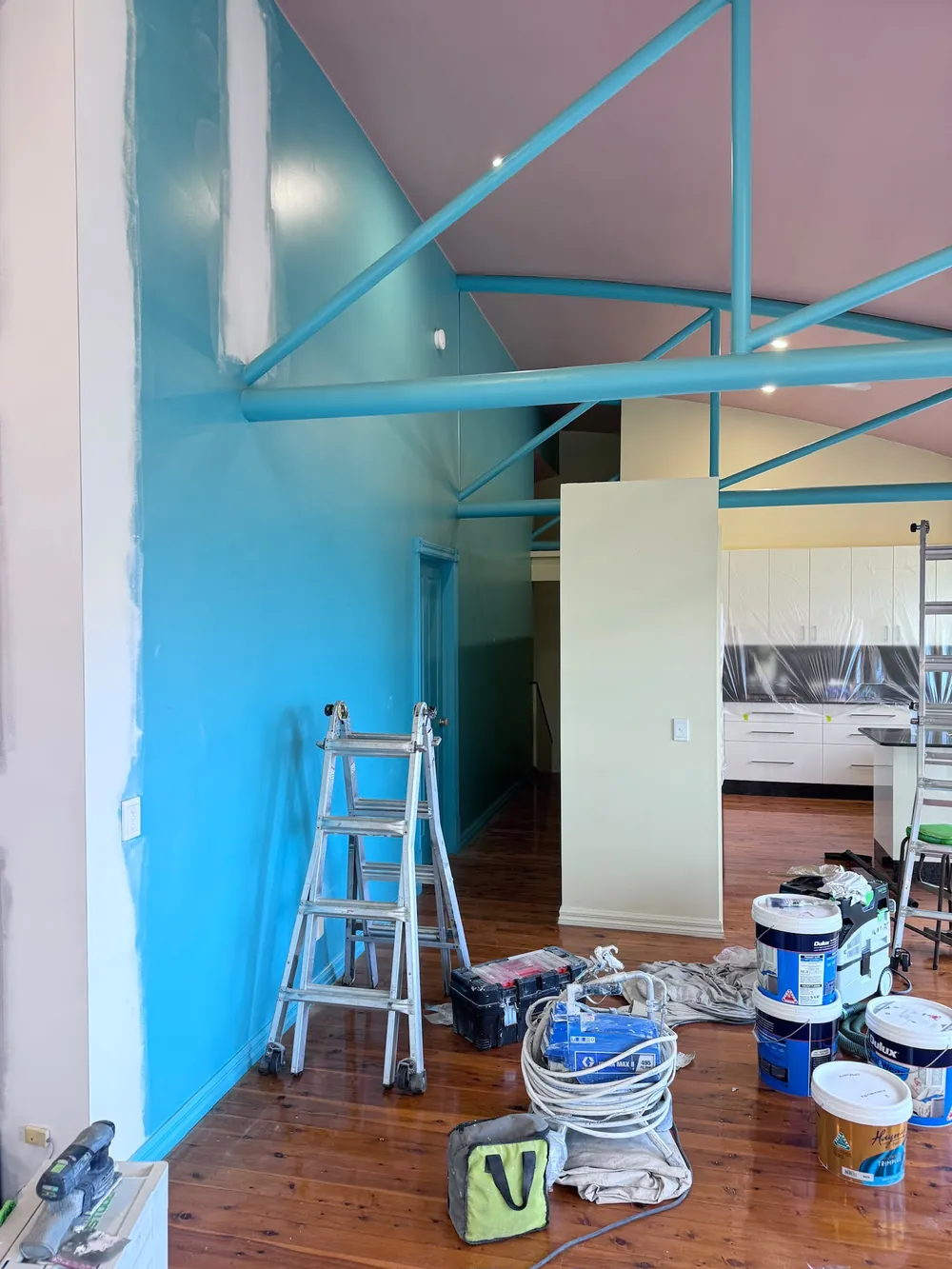 Commercial fit-out mid-repaint with exposed structural beams