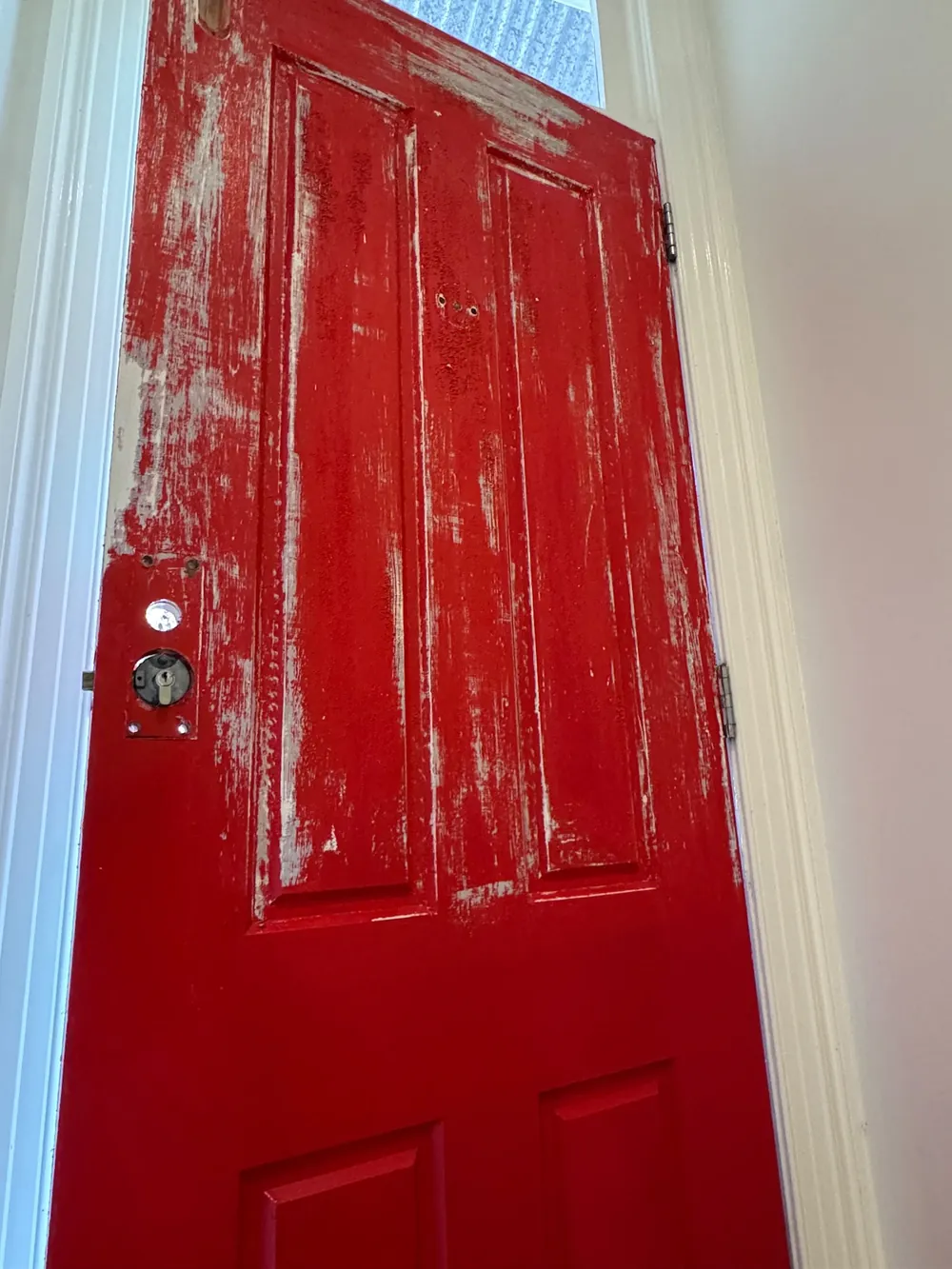 Front door mid-repaint in a fresh red gloss finish